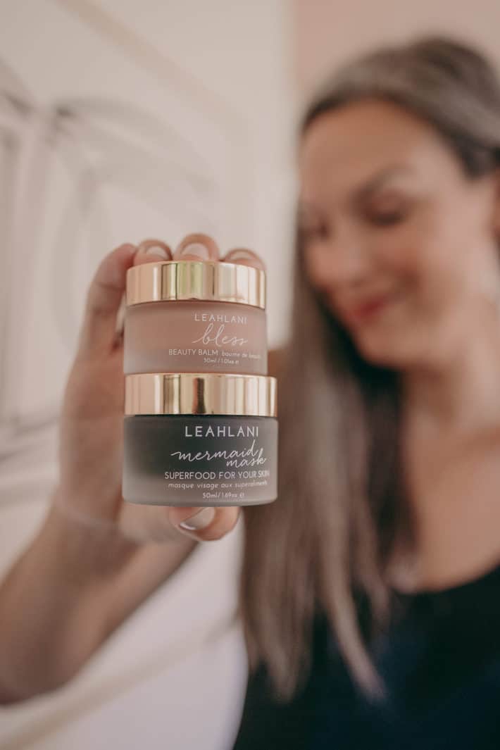 Lisa holds two jars of Leahlani organic skincare products.
