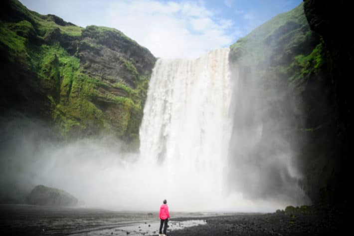 standing in front of Skógafoss Iceland waterfall