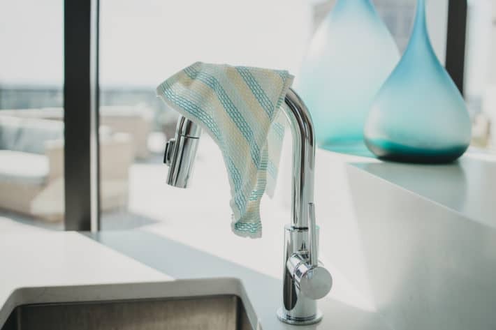 dish cloth hanging over a sink faucet 