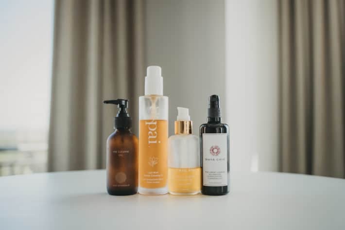 4 clean beauty oil cleansers lined up on a table
