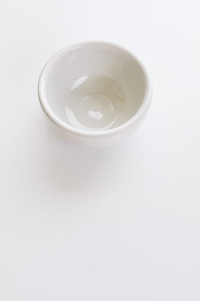 a white shallow bowl on a white backdrop 