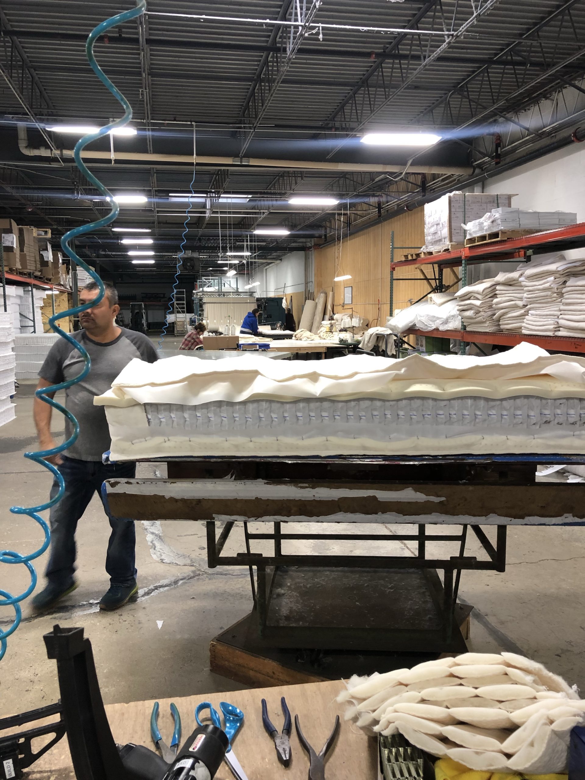 a man assembling a mattress in a factory