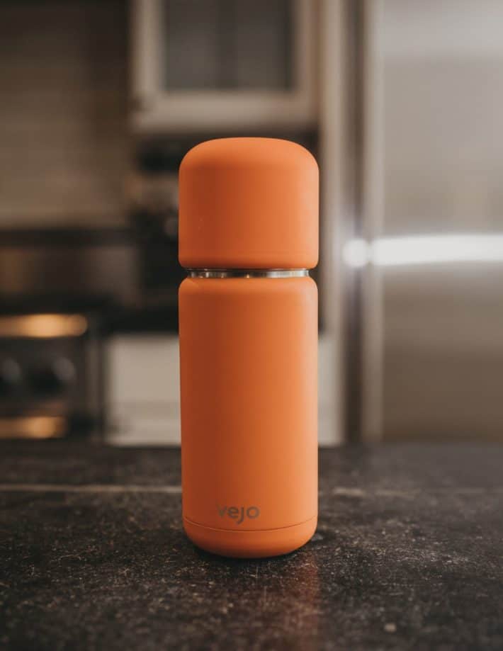 orange Vejo portable smoothie blender on a kitchen counter
