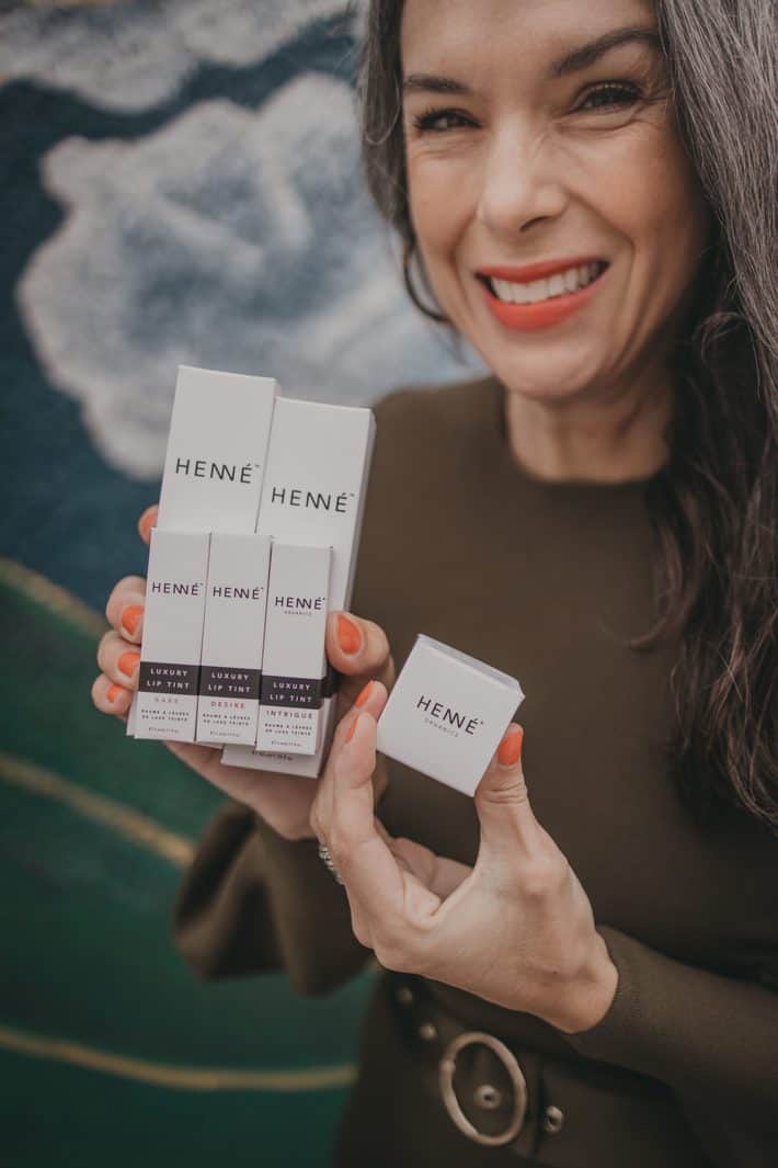 woman holding skincare products from Henne