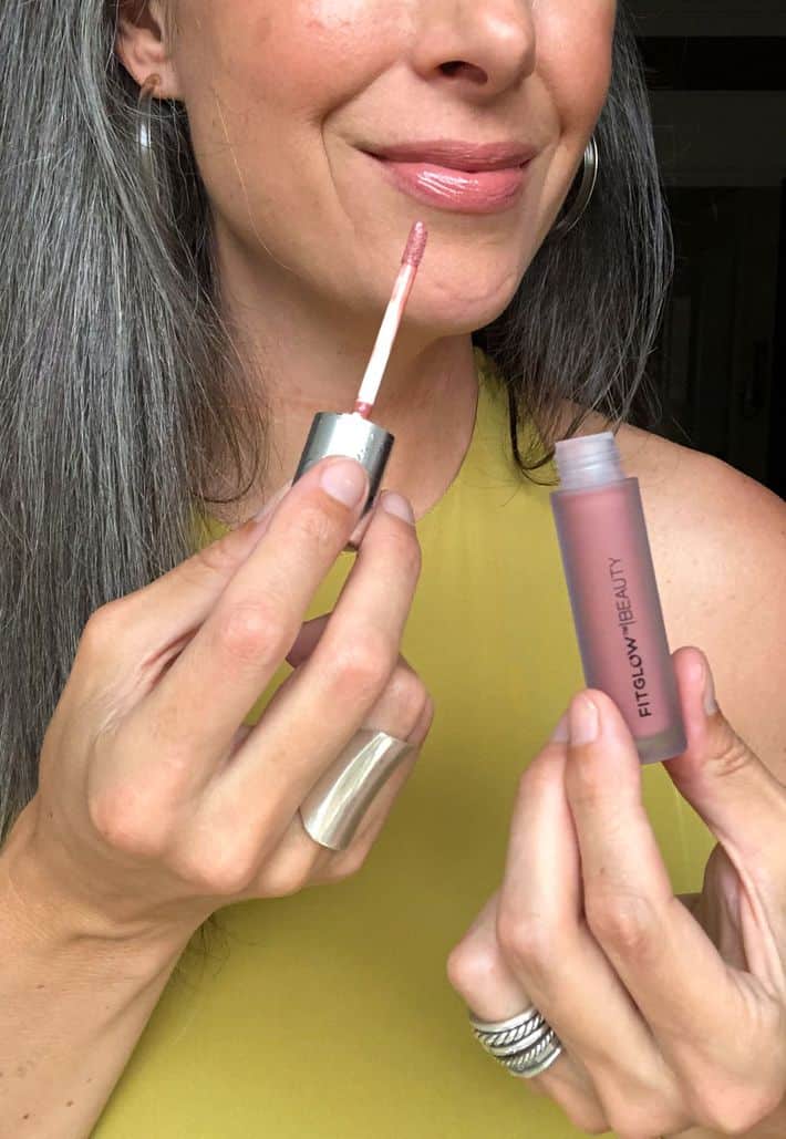 Gray hair woman applying lipstick
