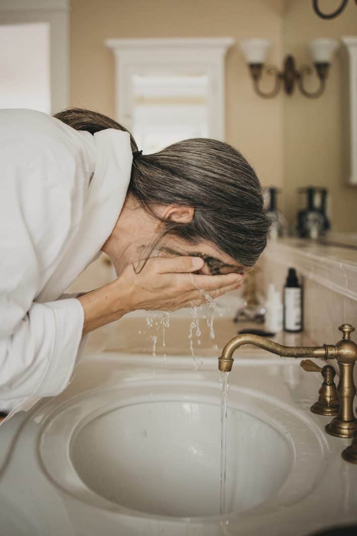 woman washing her face in the morning
