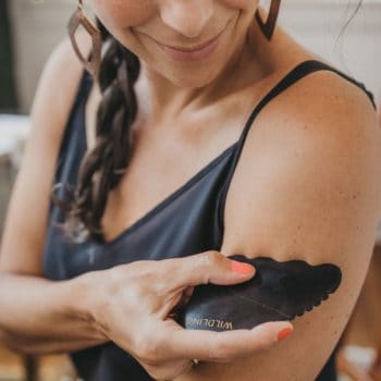 woman using gua sha on arm