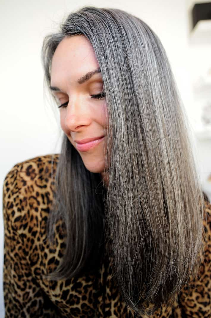 Woman with straight long gray hair using overtone
