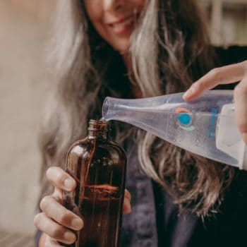 woman pouring cleaner mix into bottle