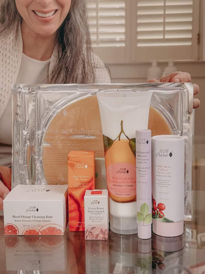 lisa sits behind a collection of 100% Pure skincare