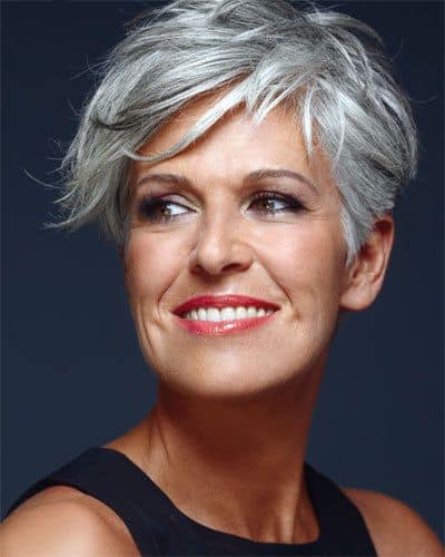 woman with short gray hair and red lipstick looks off to the side