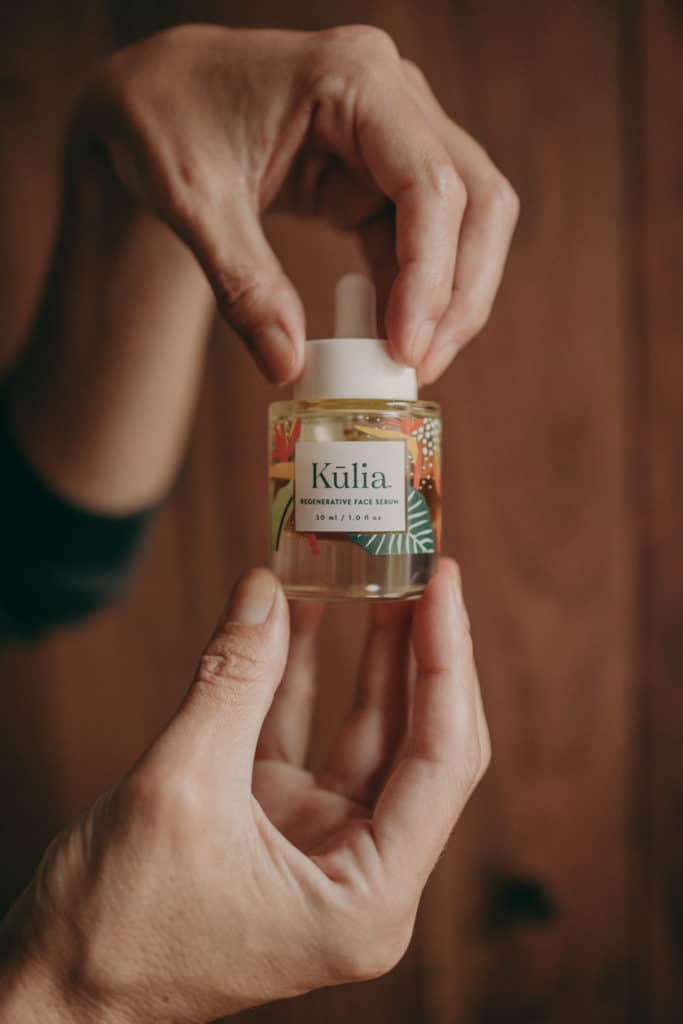 hands holding a bottle of kulia face serum