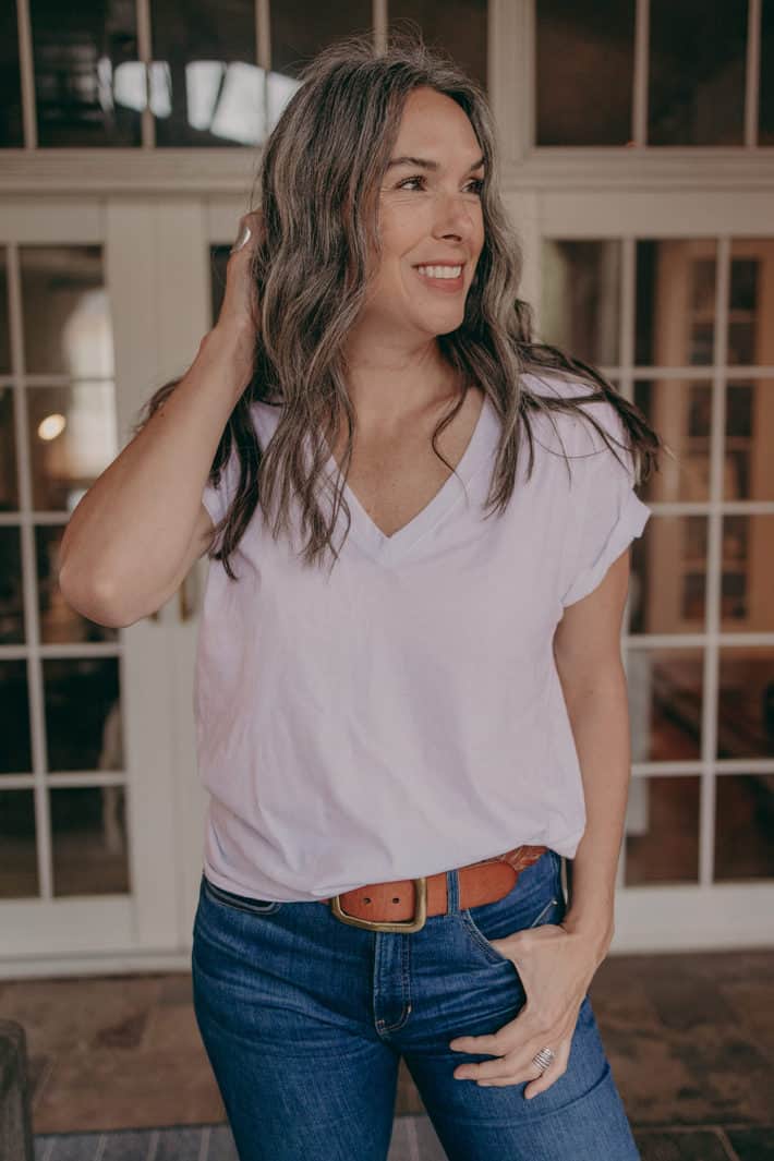 woman smiling in a white t shirt and jeans
