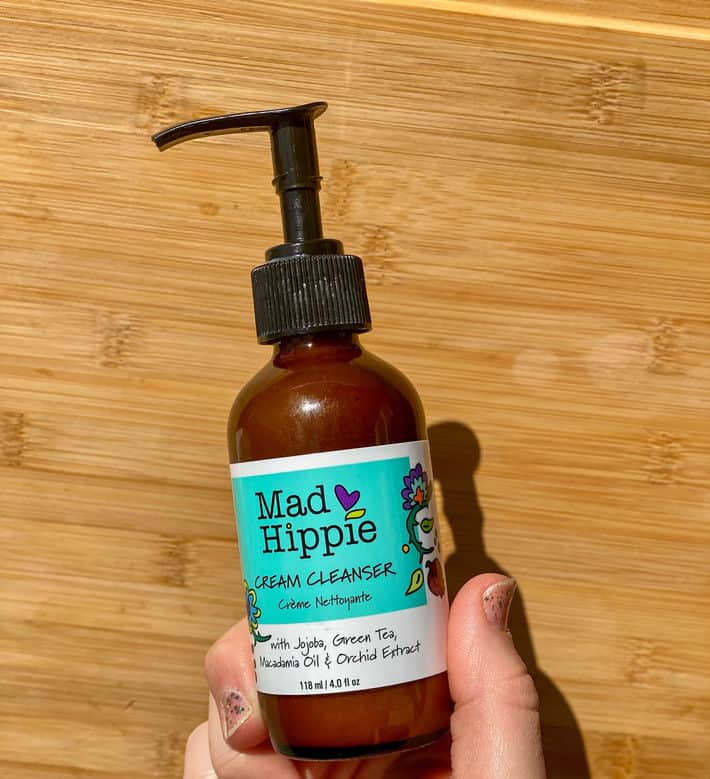 Bottle of mad hippie cream cleanser in front of wood background