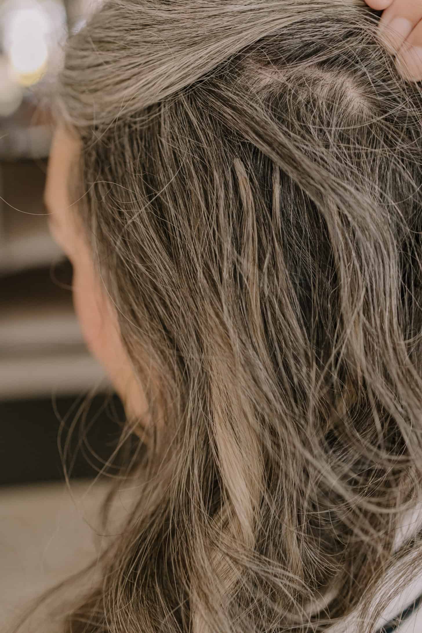 Close up of long gray hair extensions on a woman