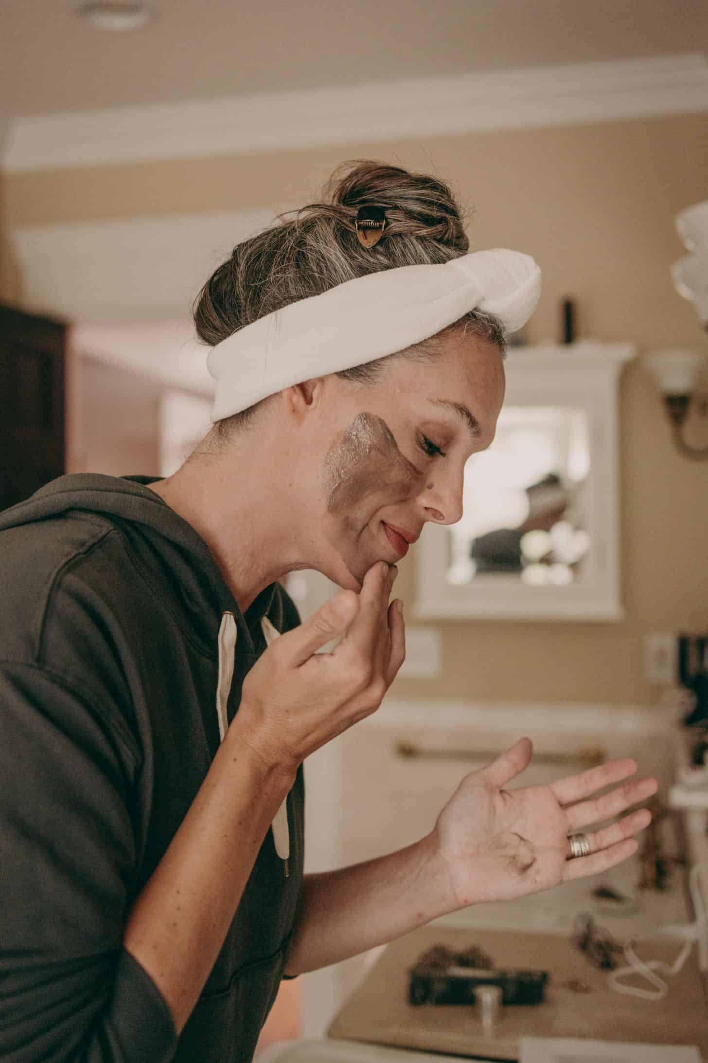 a woman applies a face mask to her face