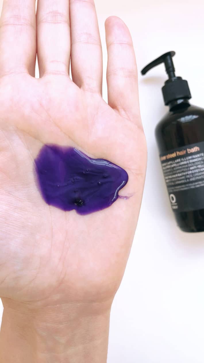 a hand with purple shampoo in the palm of it