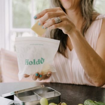 a woman packs a lunch using a HoldOn brand compostable baggie