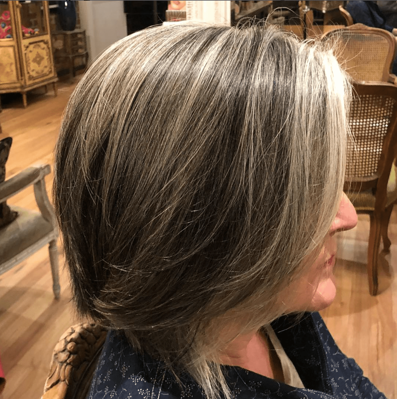 the side view of a woman growing out gray hair with added highlights