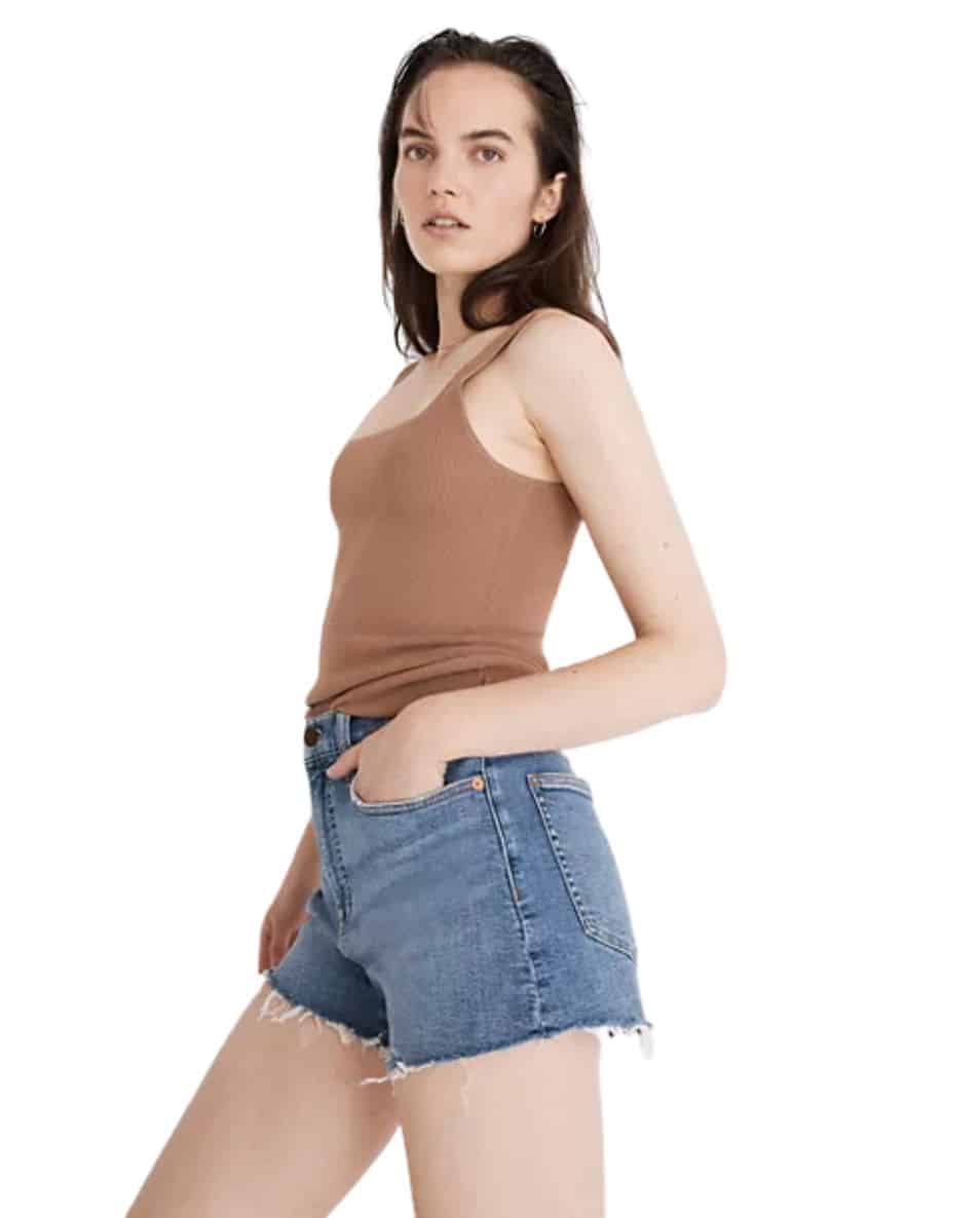 the side view of a woman wearing madewell cutoff denim shorts