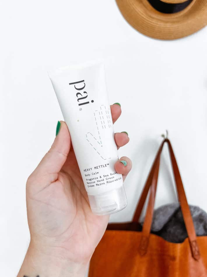 a close up of a hand holding a tube of pai heavy mettle hand cream