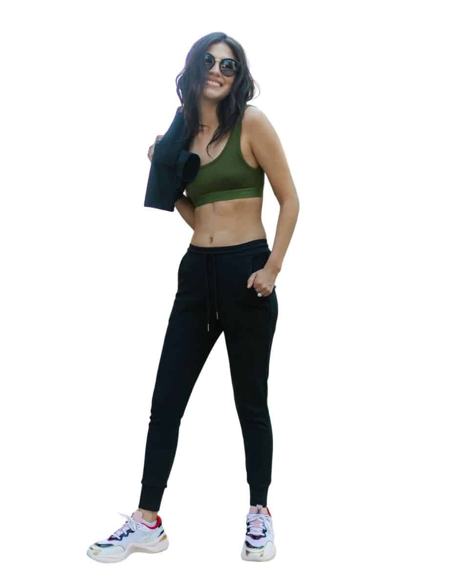 a pair of fitted black joggers on a woman wearing a green sports bra