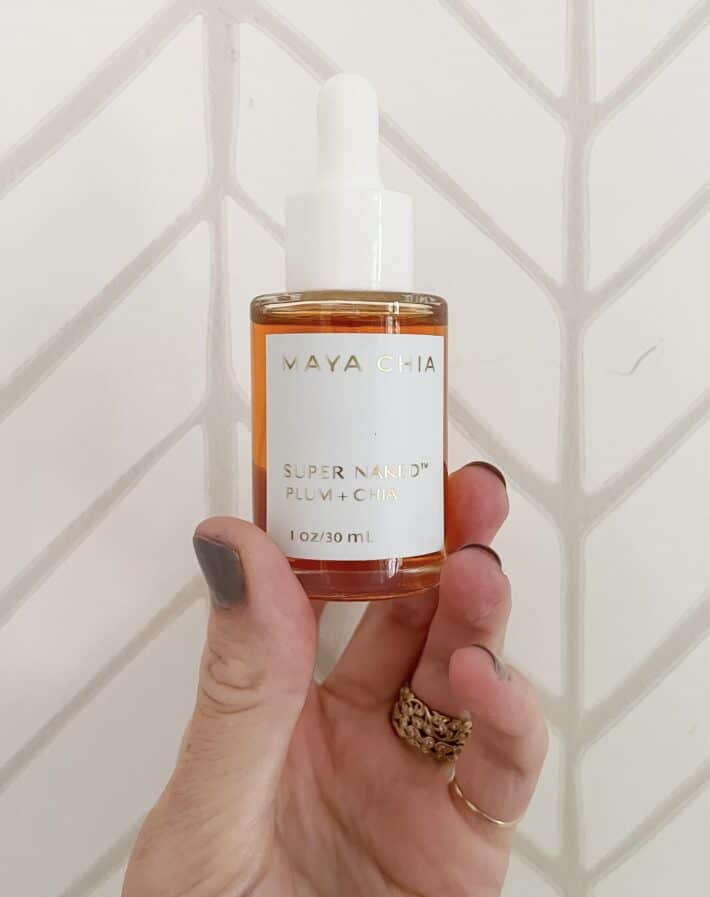 a bottle of maya chia super naked is held up 