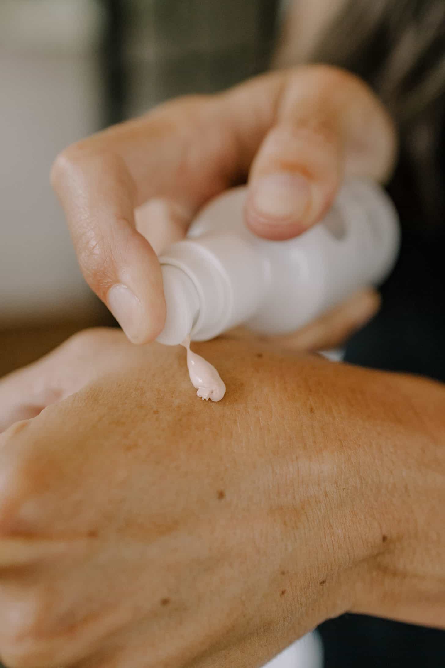 a close up of true botanicals spf being applied to a hand
