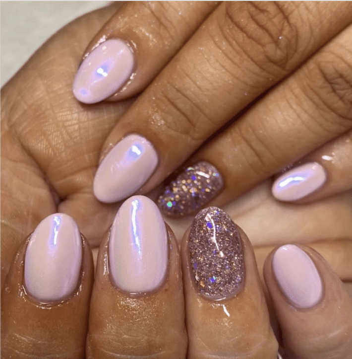 a close up of two hands with a glazed donut style manicure